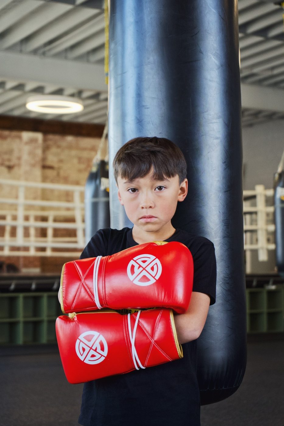 Kid boxer with red Gopa gloves at the heavy bag