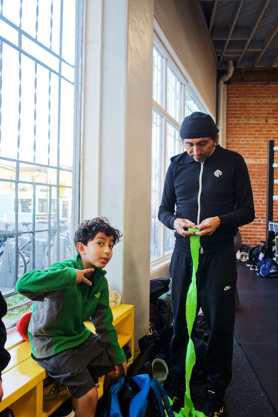 Coach wrapping a young boxer hands before training in Oakland
