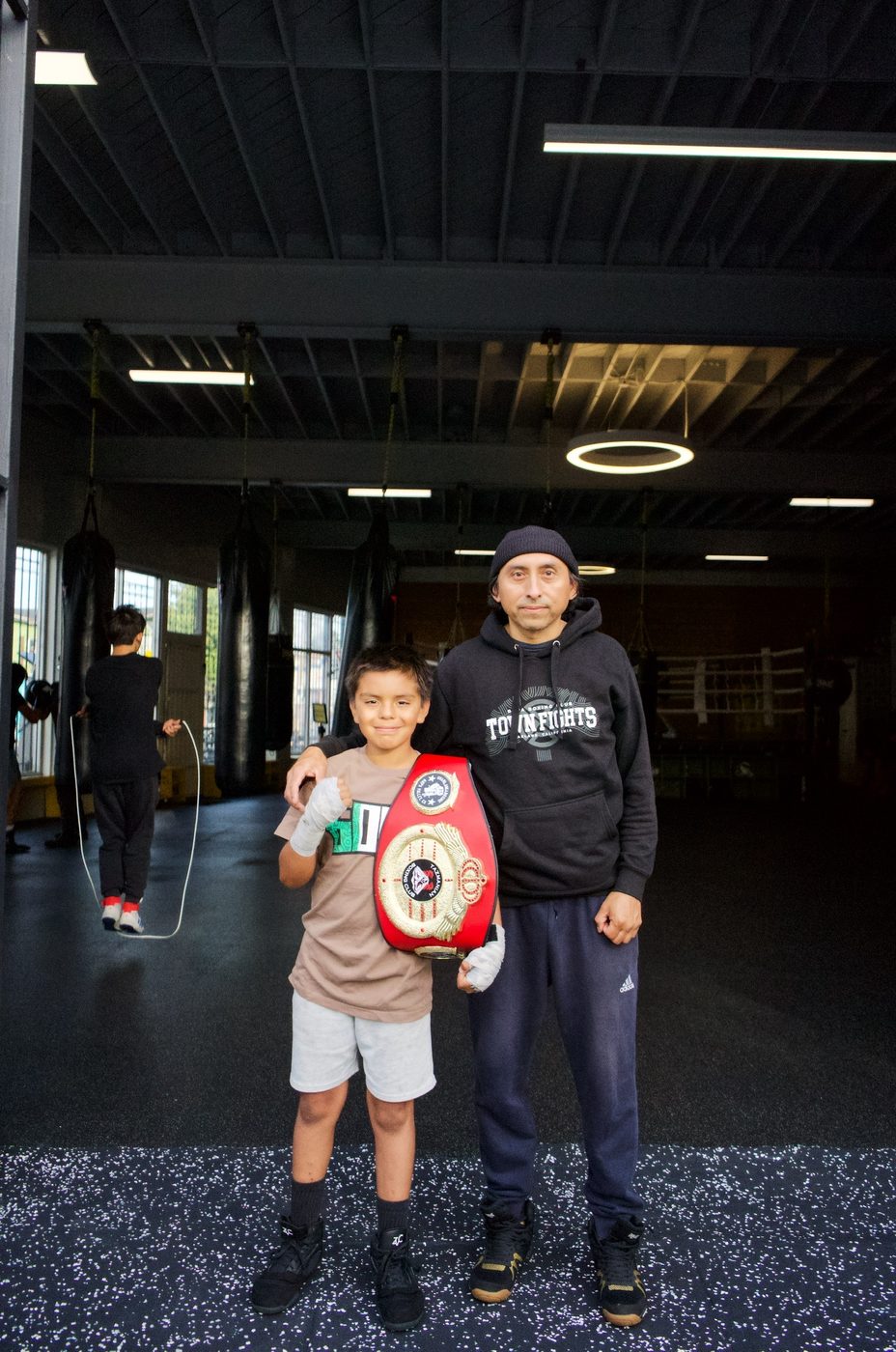Young champion with his title belt and coach at Gopa Boxing Club