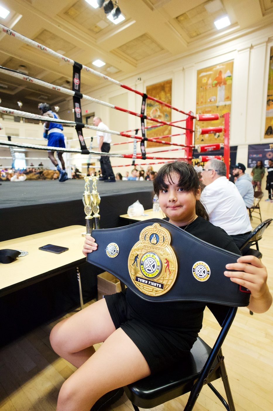 Young boxer holding the Town Fights championship belt