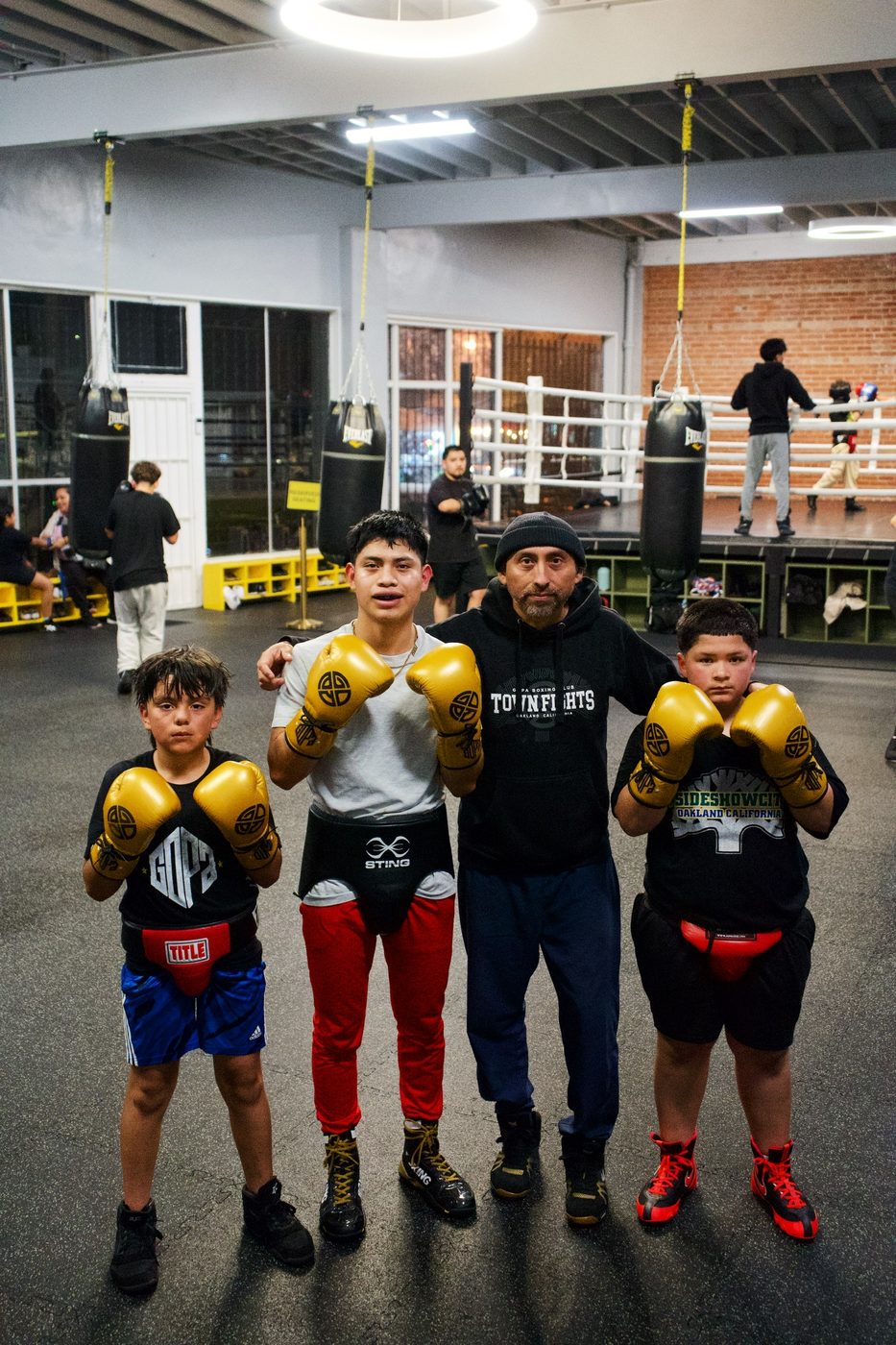 Young boxers in gold gloves with their coach in Oakland
